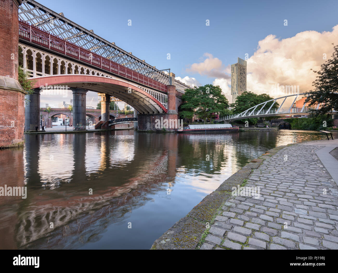 Tôt le matin vue depuis le chemin de halage le long du Canal de Bridgewater dans le Castlefield, Manchester, montrant le MSJAR et ponts du marchand et l'hôtel Hilton Banque D'Images