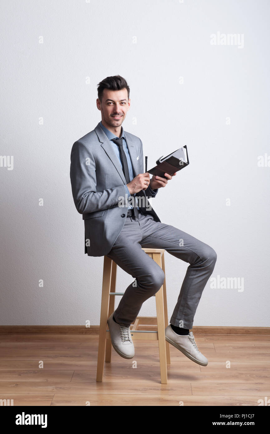 Portrait of a young man avec un stylo et un journal dans un studio, la planification. Banque D'Images