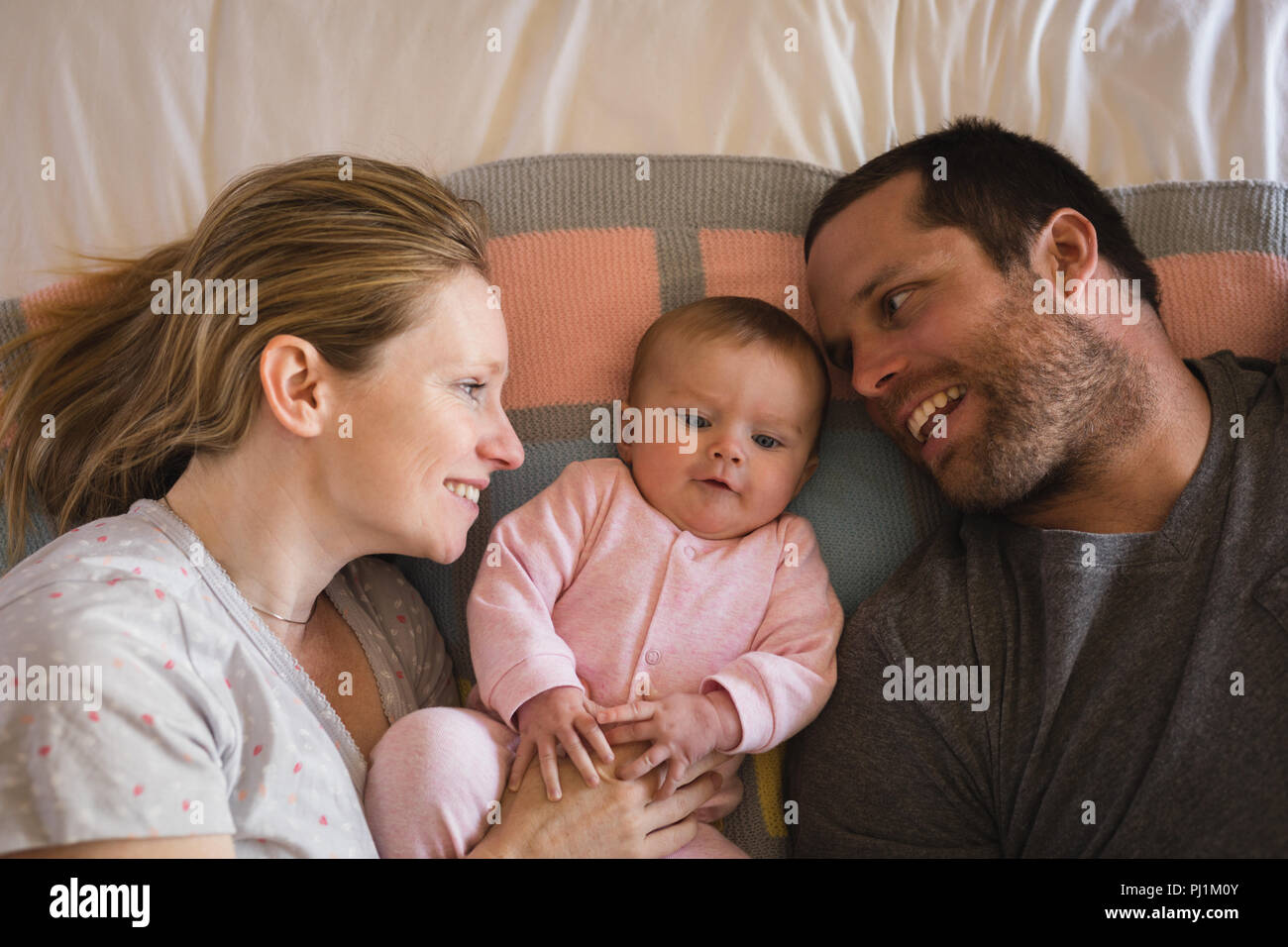 Les parents avec bébé couché sur le lit dans la chambre Banque D'Images