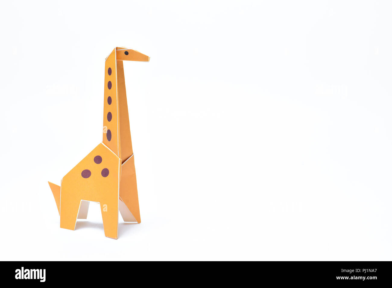 Un jaune girafe origami se dresse sur un fond blanc Banque D'Images