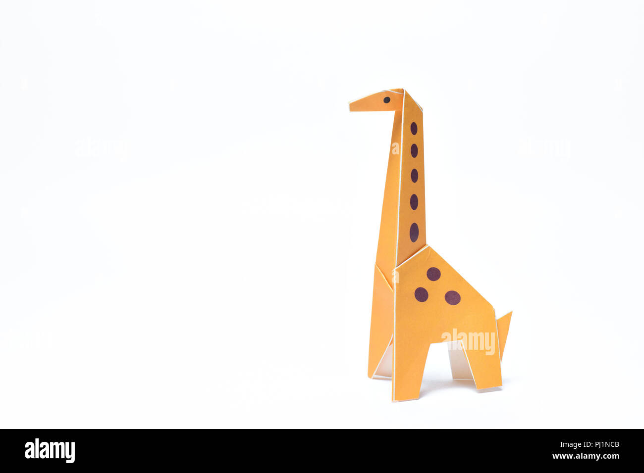 Une girafe origami jaune se dresse sur un fond blanc Banque D'Images