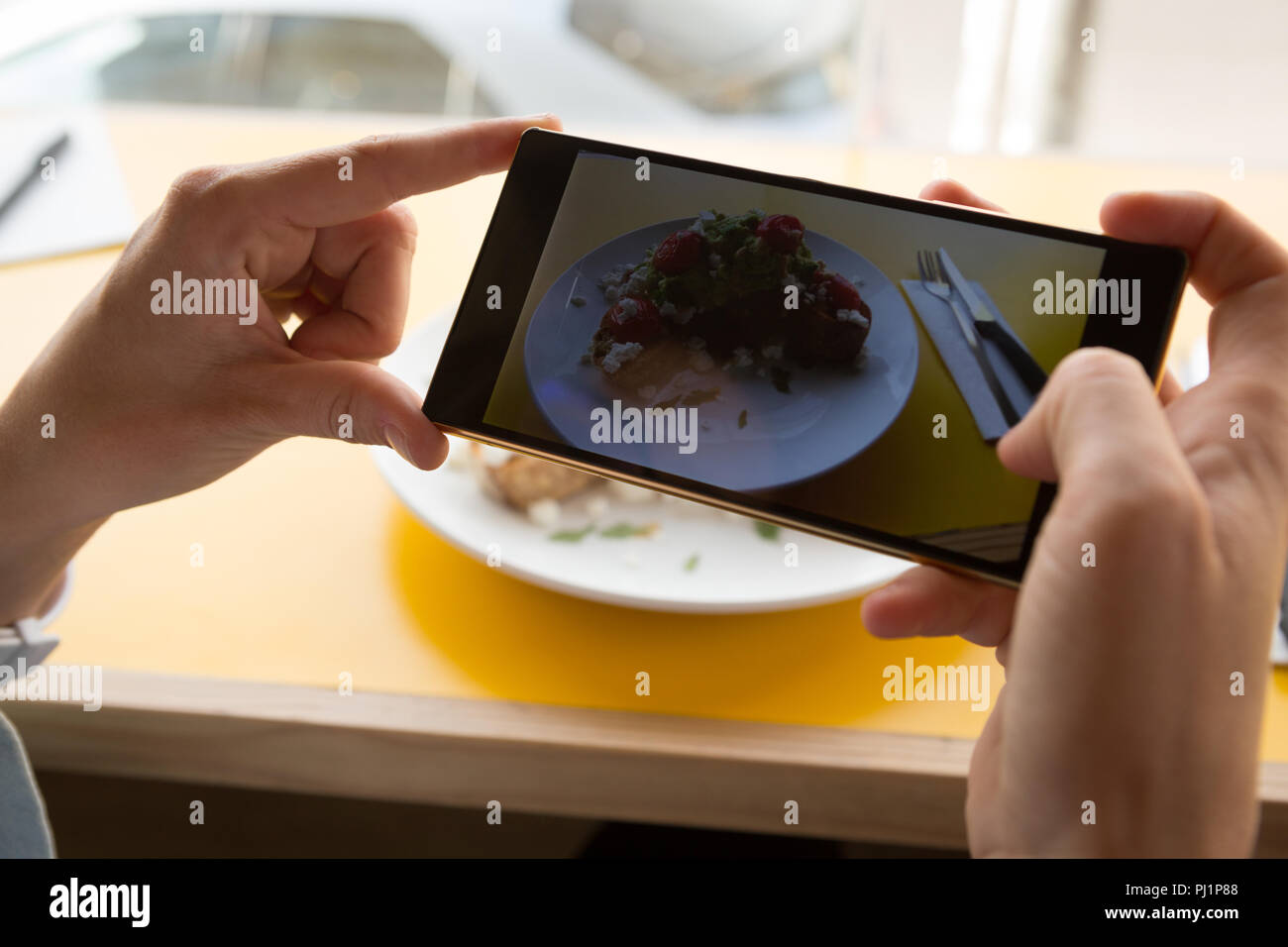 Woman taking photo d'aliments sur la plaque au café Banque D'Images