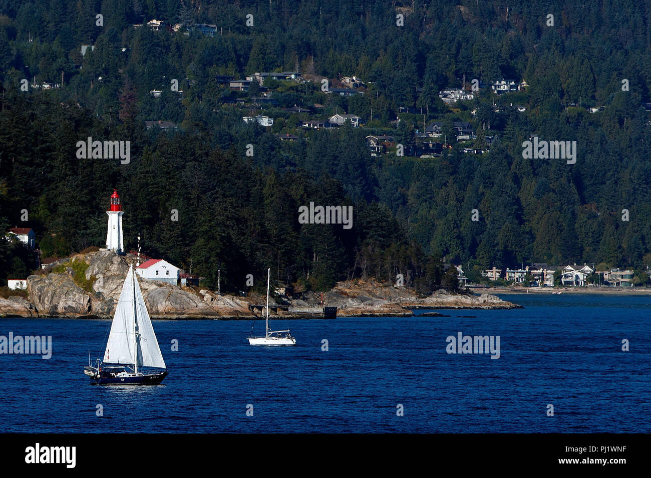 Le phare de Point Atkinson avec voilier passant, West Vancouver, British Columbia, Canada Banque D'Images