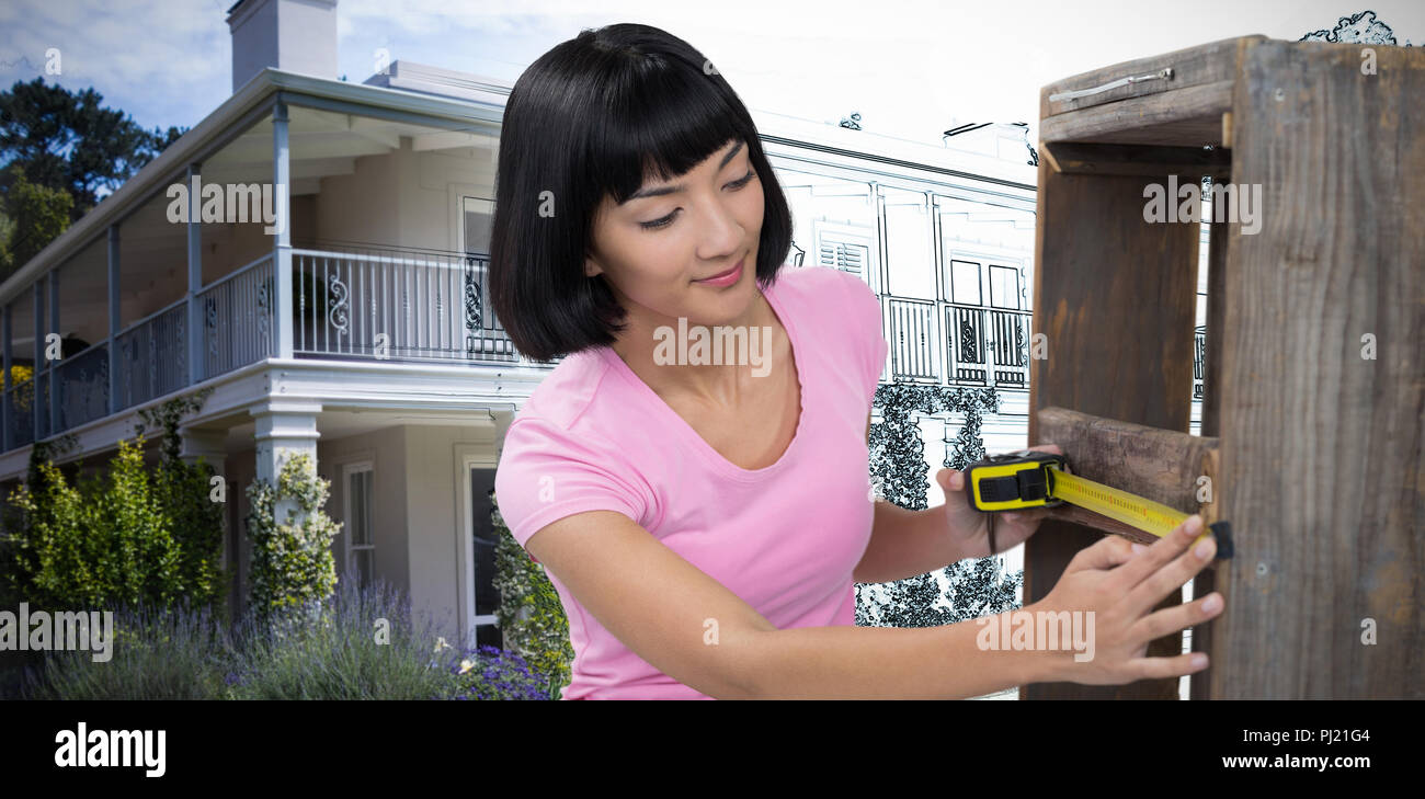 Image composite de woman measuring meubles avec ruban de mesure Banque D'Images