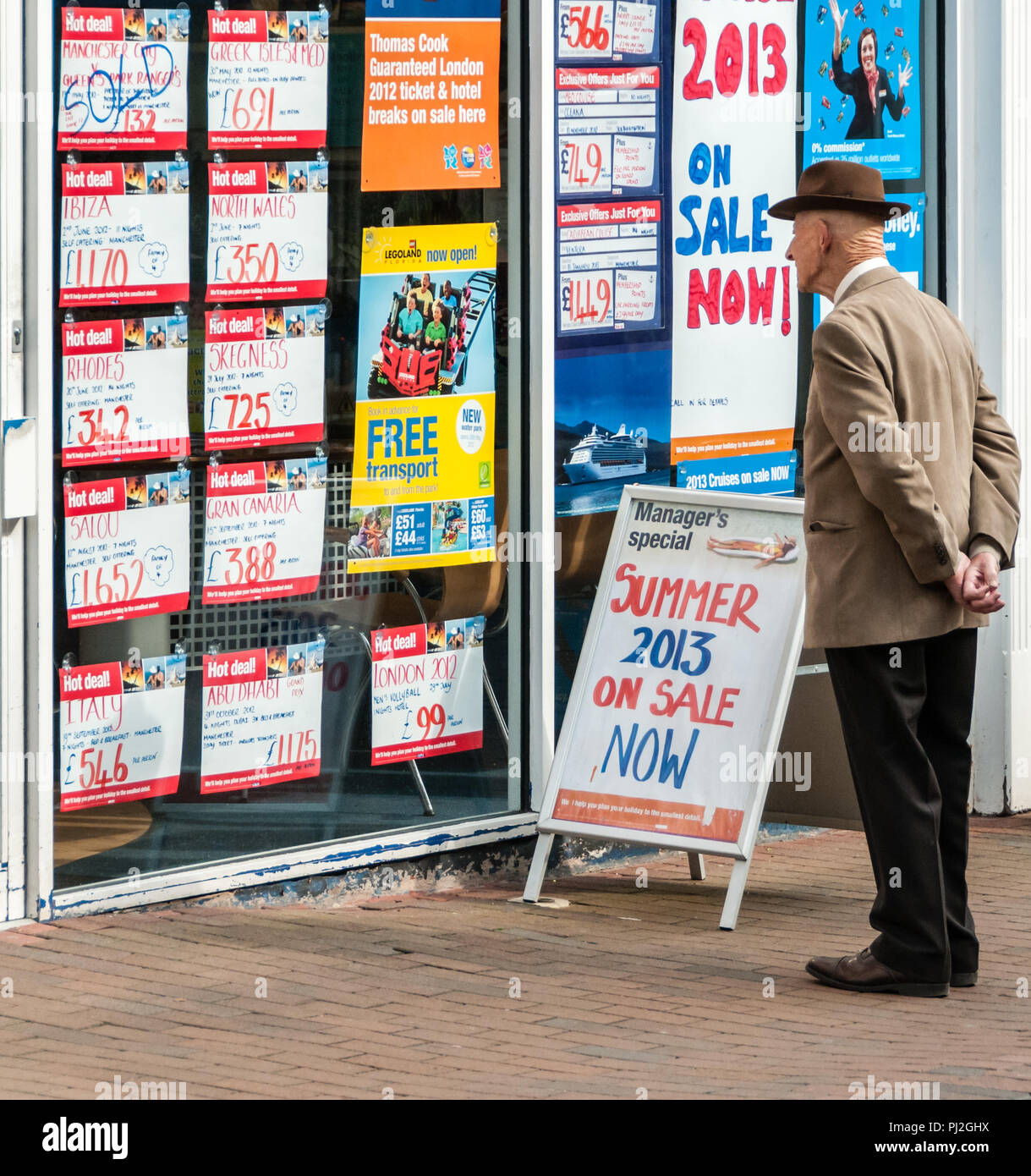 Un homme âgé à la maison de vacances offre à l'agent de voyages en vitrine à Macclesfield Banque D'Images