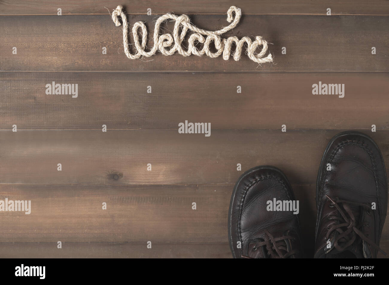 L'homme en cuir marron, chaussure et texte de bienvenue sur fond de bois,Vue de dessus pour copy space Banque D'Images
