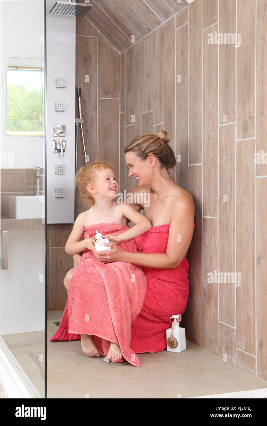Moother et sa fille dans une cabine de douche accessible en fauteuil roulant dans une salle de bains moderne Banque D'Images