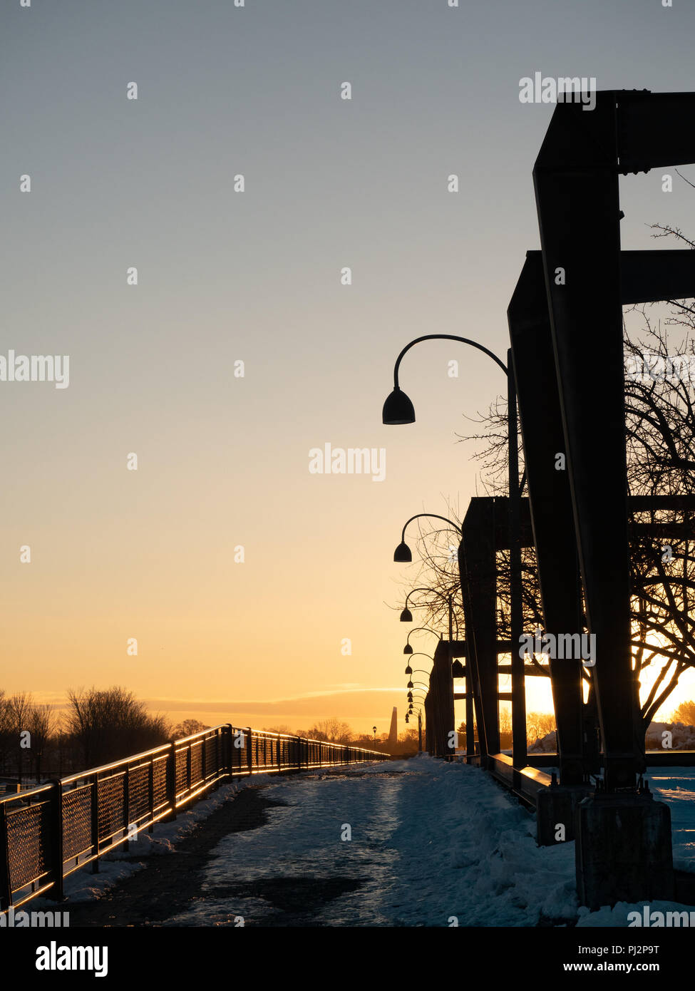 Une rangée de structures métalliques au Vieux Port ou Vieux Port de Montréal Québec, Canada. Photographié au lever du soleil dans l'hiver avec des arbres sans feuilles dans la b Banque D'Images
