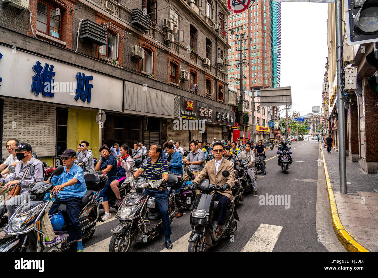 Shanghai, Chine - Chinois les hommes et femmes trajet quotidien sur une rue latérale, à proximité de Nanjing Road. Banque D'Images