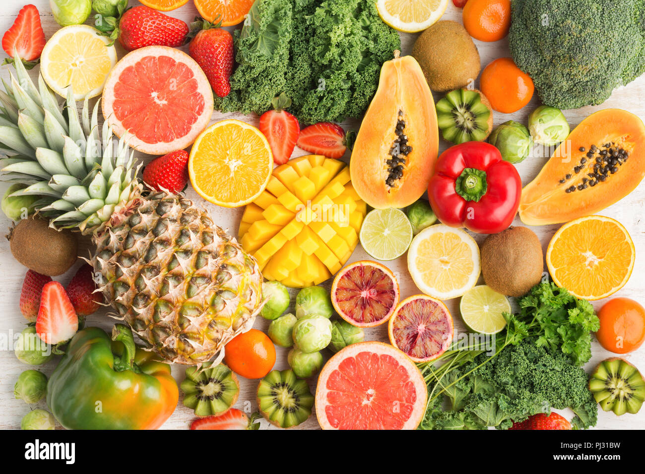 Les fruits et légumes riches en vitamine C motif, les oranges pamplemousses mangues ananas kiwi citron poivre chou brocoli, choux de papaye sur le tableau blanc, vue du dessus, selective focus Banque D'Images
