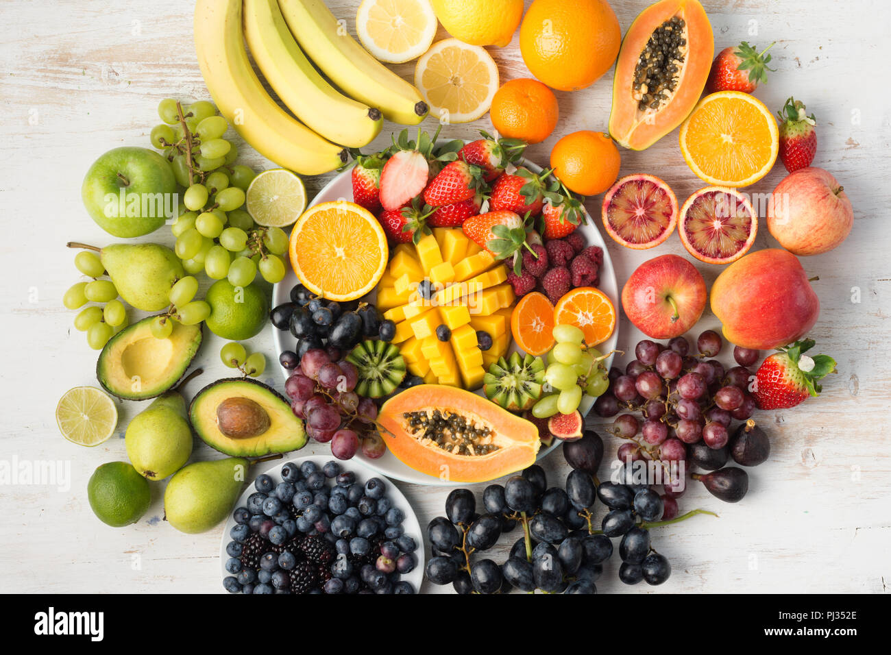 Fond d'aliments sains, assortiment de fruits en couleurs arc-en-ciel sur le tableau blanc disposées en cercle, vue du dessus, selective focus Banque D'Images