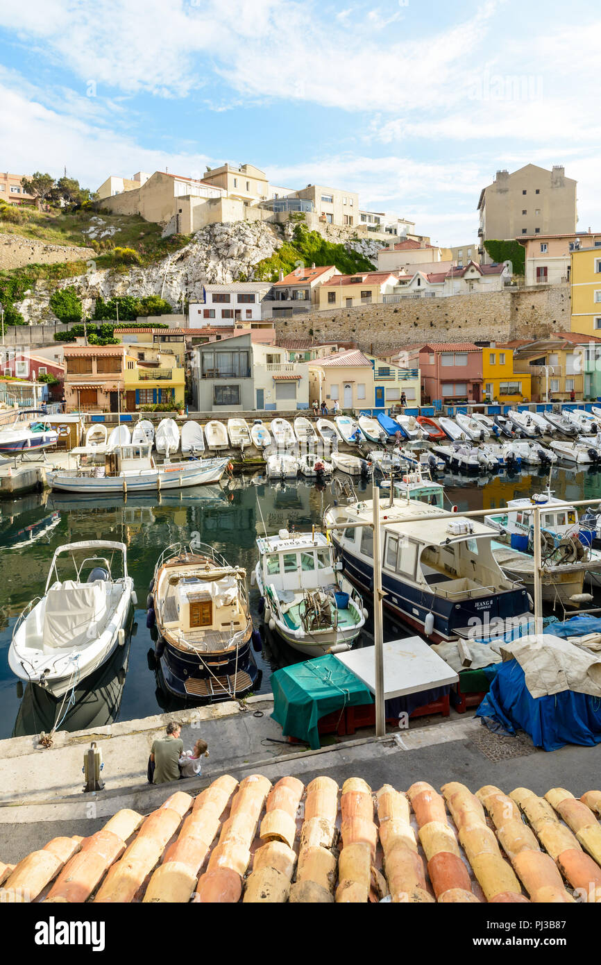 Le petit port du Vallon des Auffes à Marseille à la fin de la journée avec ses bateaux amarrés devant cabanons colorés et maisons en dessous de la falaise. Banque D'Images