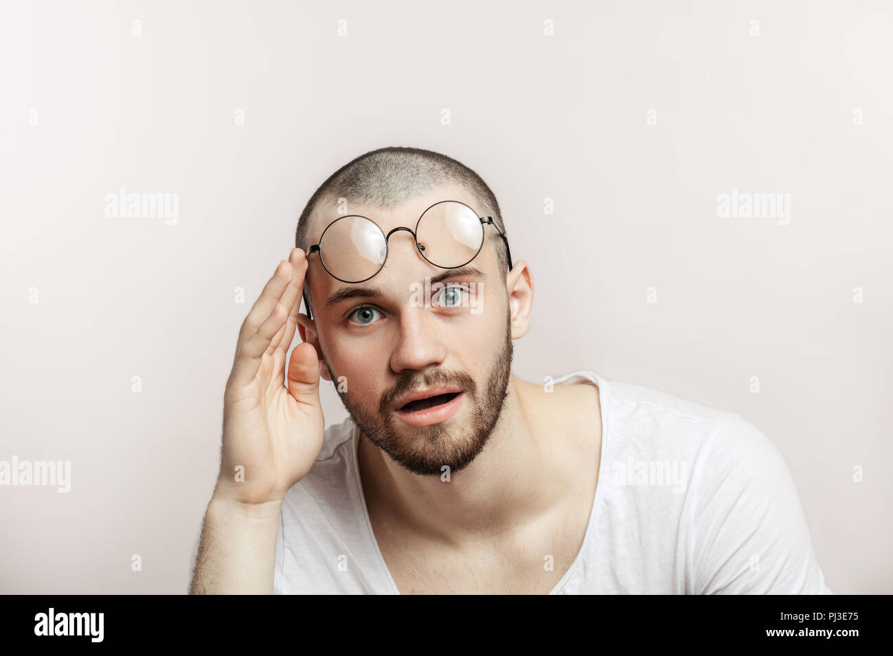 Surpris composite les lunettes sur son front sur fond blanc Photo Stock -  Alamy