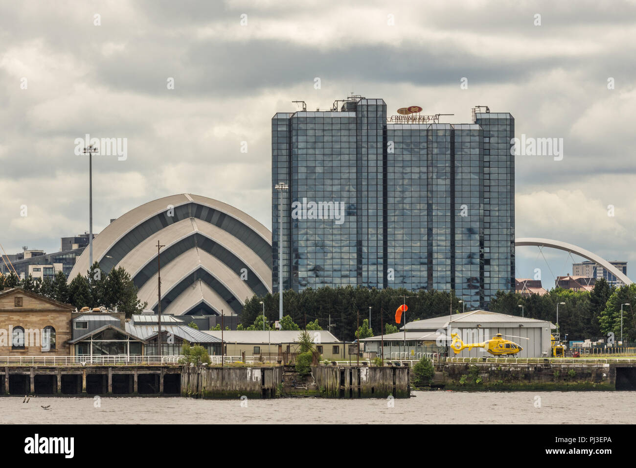 Glasgow, Scotland, UK - 17 juin 2012 : Crown Plaza Hotel et l'Armadillo sec et une partie de la Clyde Arc sous les nuages. Hélicoptère jaune sur la Rive Banque D'Images