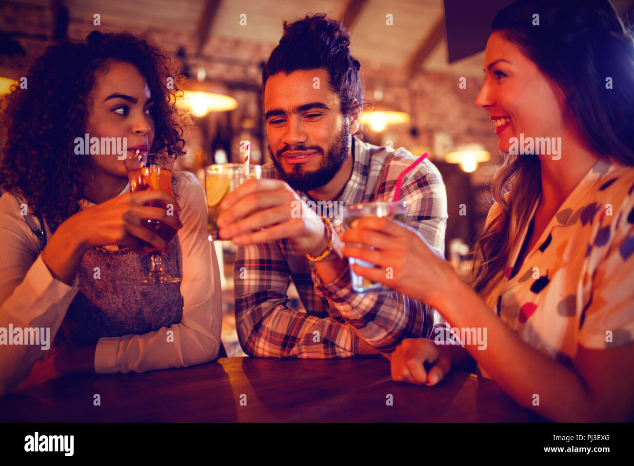 Jeunes amis en interaction les uns avec les autres d'avoir des boissons Banque D'Images