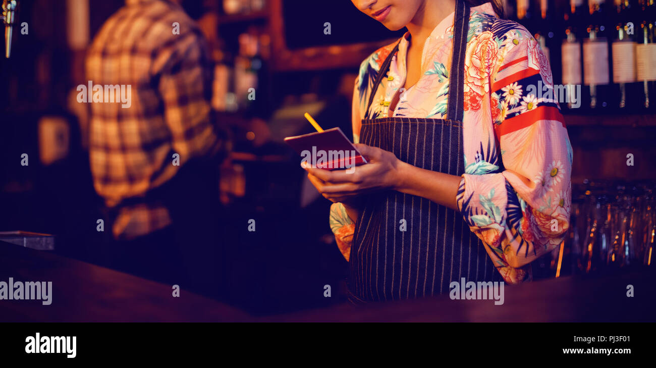 Waitress vue sur le bloc-notes au comptoir Banque D'Images