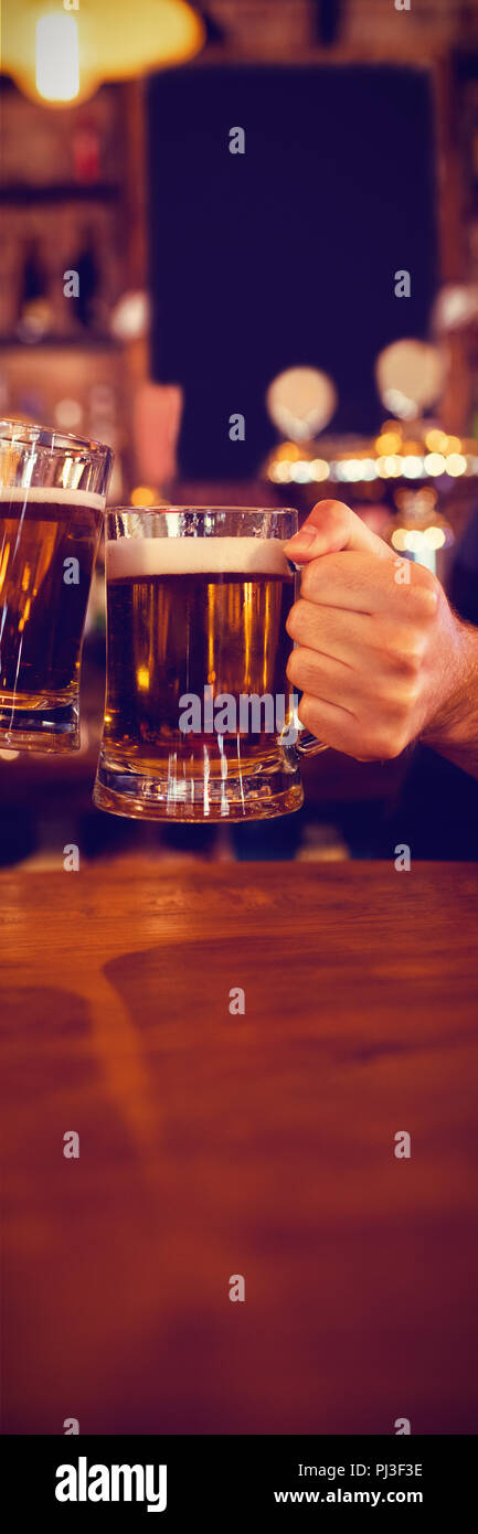 Deux jeunes hommes toasting leurs verres Banque D'Images