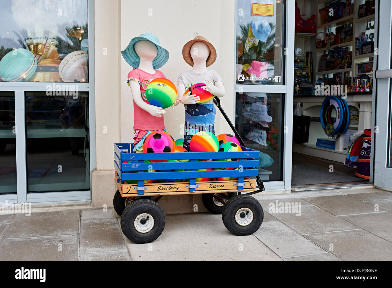 Affichage extérieur magasin de détail de vêtements d'enfants colorés et des jouets de plage sur le trottoir avant de Seaside en Floride, aux États-Unis. Banque D'Images