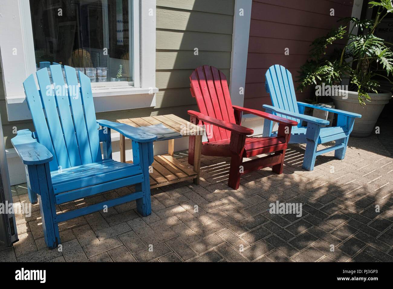 Chaises Adirondack colorés vide sur patio de brique en Floride, USA. Banque D'Images