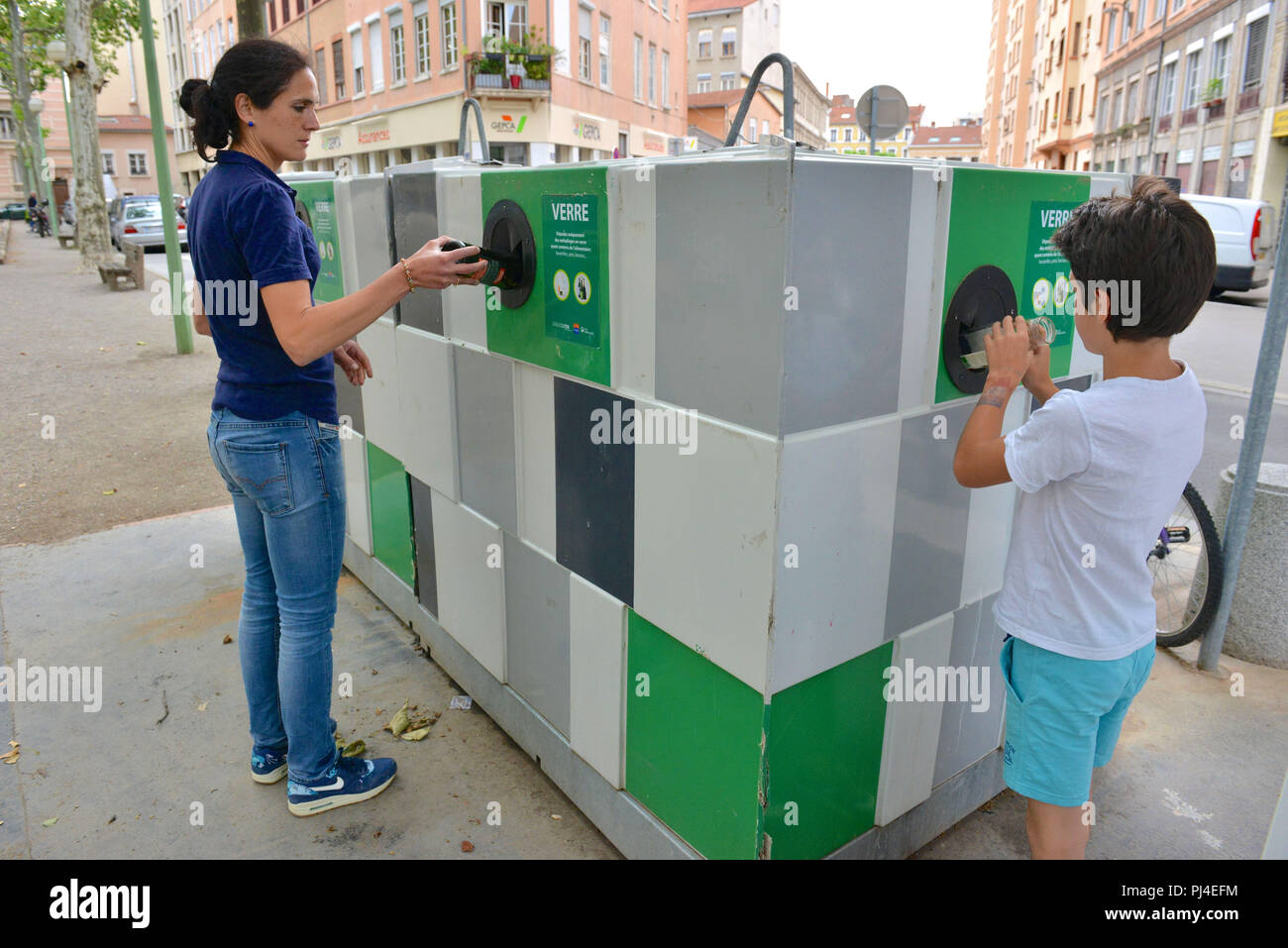 Lyon (sud-est de la France). Femme et enfant de mettre les éléments en verre dans un récipient. Autorisation modèle OK Banque D'Images