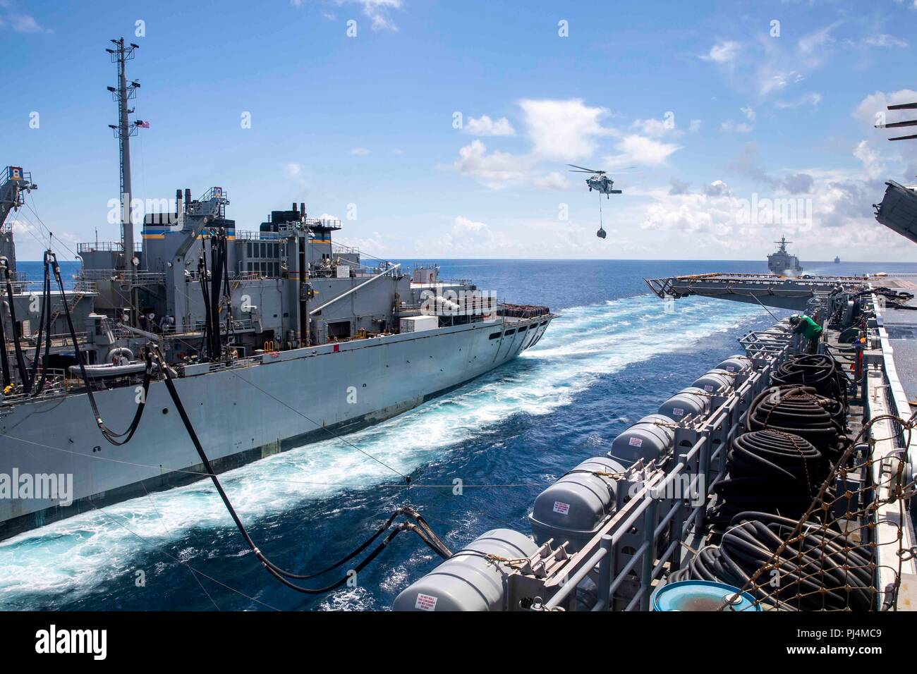 180830-N-JN023-0069 de l'OCÉAN ATLANTIQUE (Aug. 30, 2018) Un transfert Seahawk MH-60S'approvisionner auprès de l'appui au combat rapide navire USNS Supply (T-AOE 6) pour la classe Wasp-navire d'assaut amphibie USS Kearsarge LHD (3) au cours d'un ravitaillement en mer dans le cadre du groupe aéronaval (CSG) Quatre 4 groupe amphibie, Marine Expeditionary Unit Exercise (ARGMEUEX). Groupe amphibie Kearsarge et 22e Marine Expeditionary Unit sont l'amélioration de l'intégration interarmées, la létalité et capacités collectives de l'équipe de Navy-Marine corps grâce à une planification et l'exécution de la formation difficile et réaliste Banque D'Images