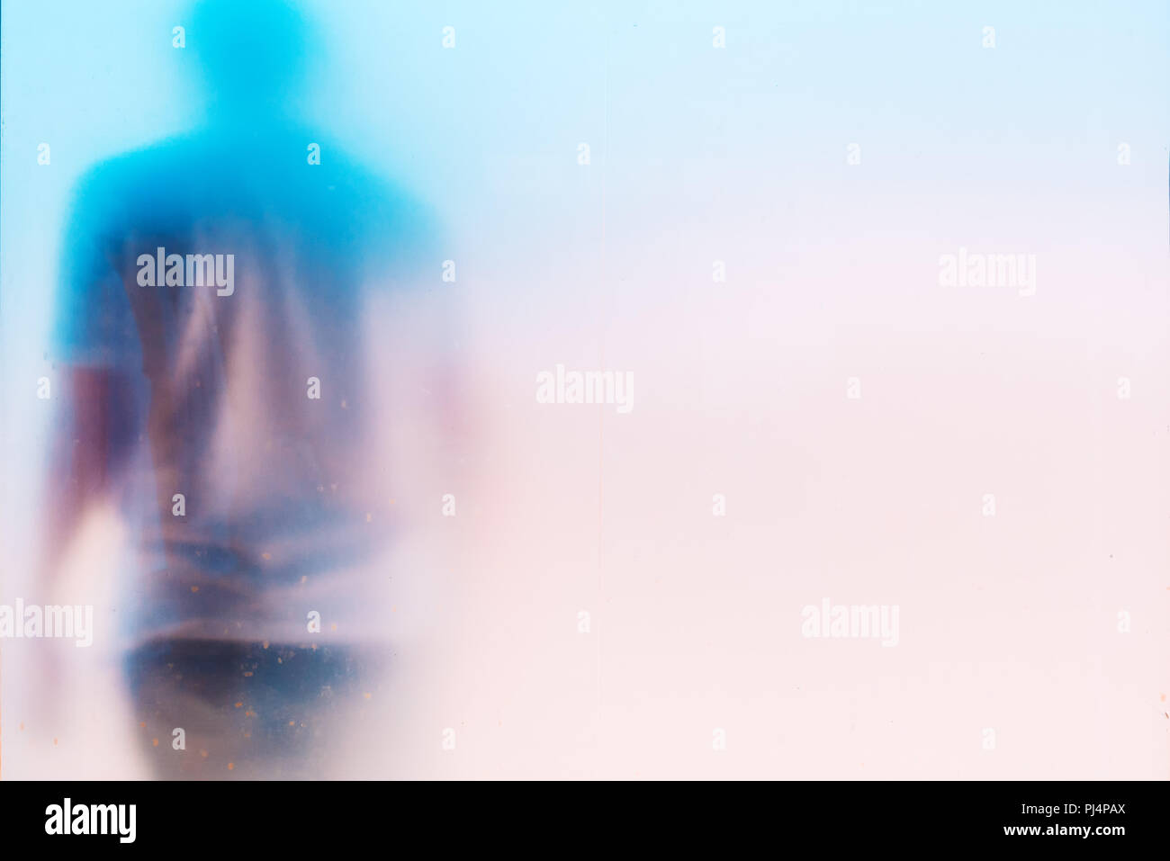 Silhouette de l'homme masculin déprimé triste méconnaissable, la tête en bas, derrière une vitre sale window Banque D'Images