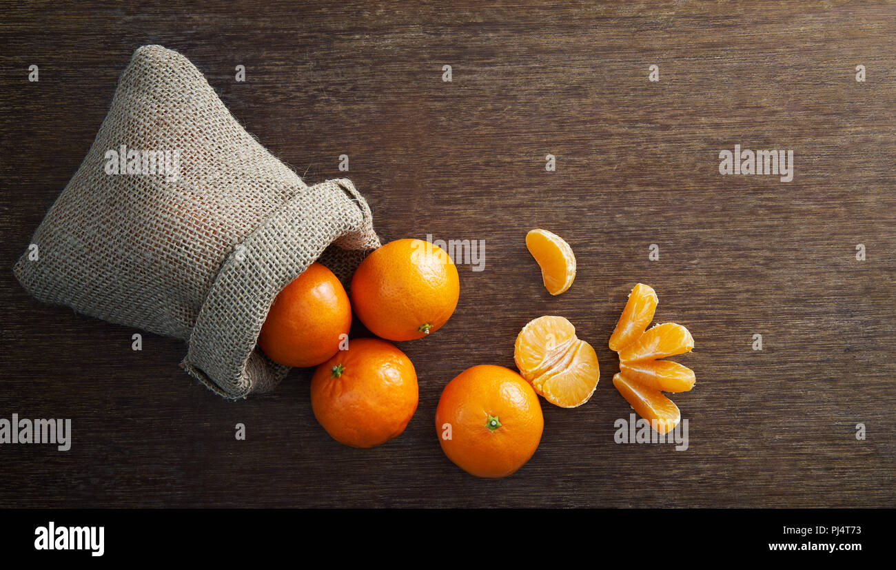 Mandarines de sac de jute renversé Banque D'Images