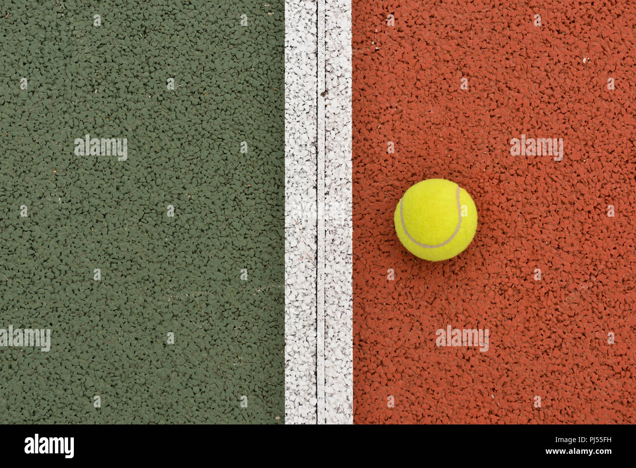 Tennis : balle jaune et ligne blanche sur un fond ocre, semblable à l'argile Banque D'Images