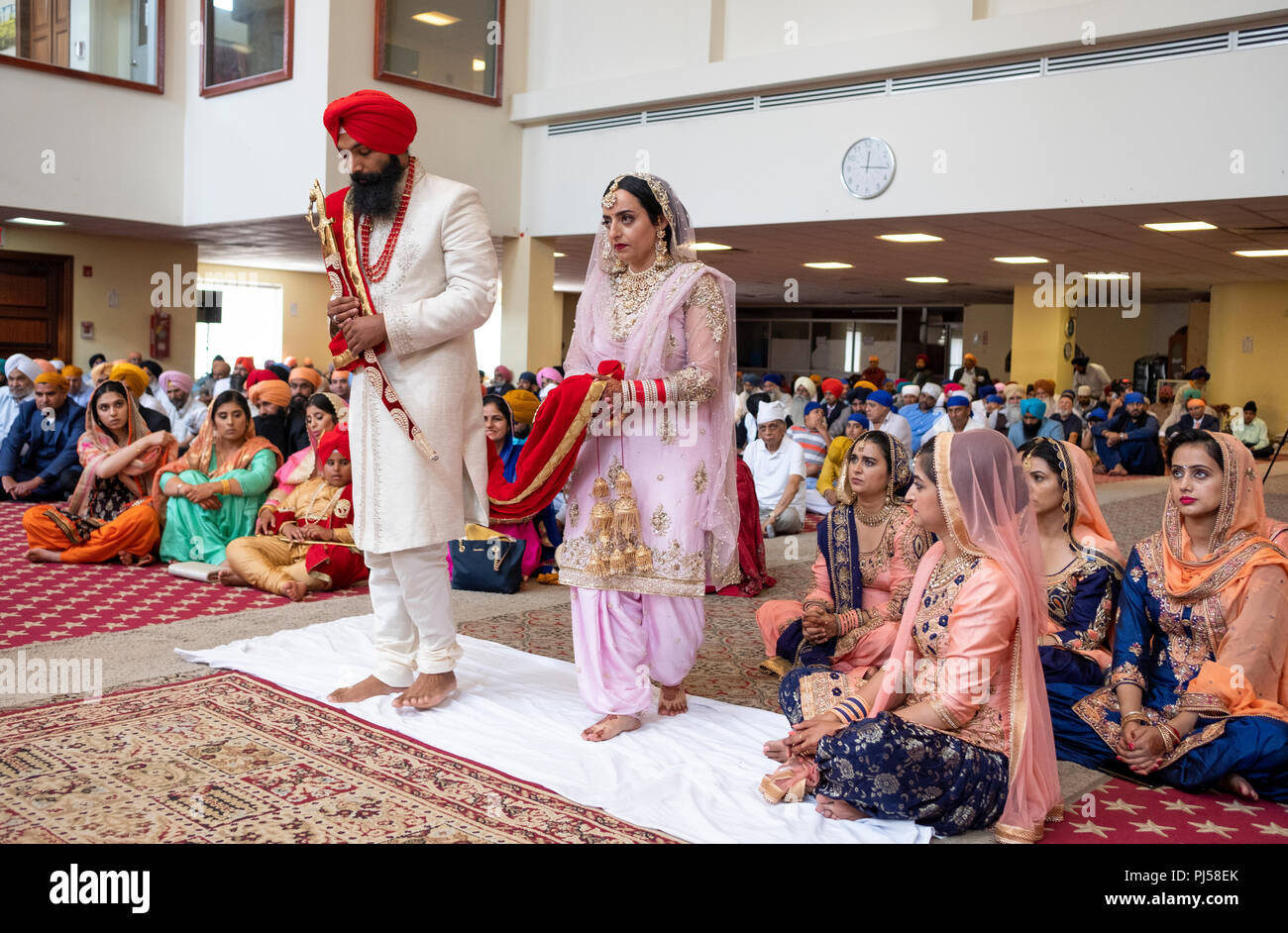 Un Sikh mariée et le marié dans un temple pendant leur cérémonie de mariage. Dans le Queens, New York City Banque D'Images