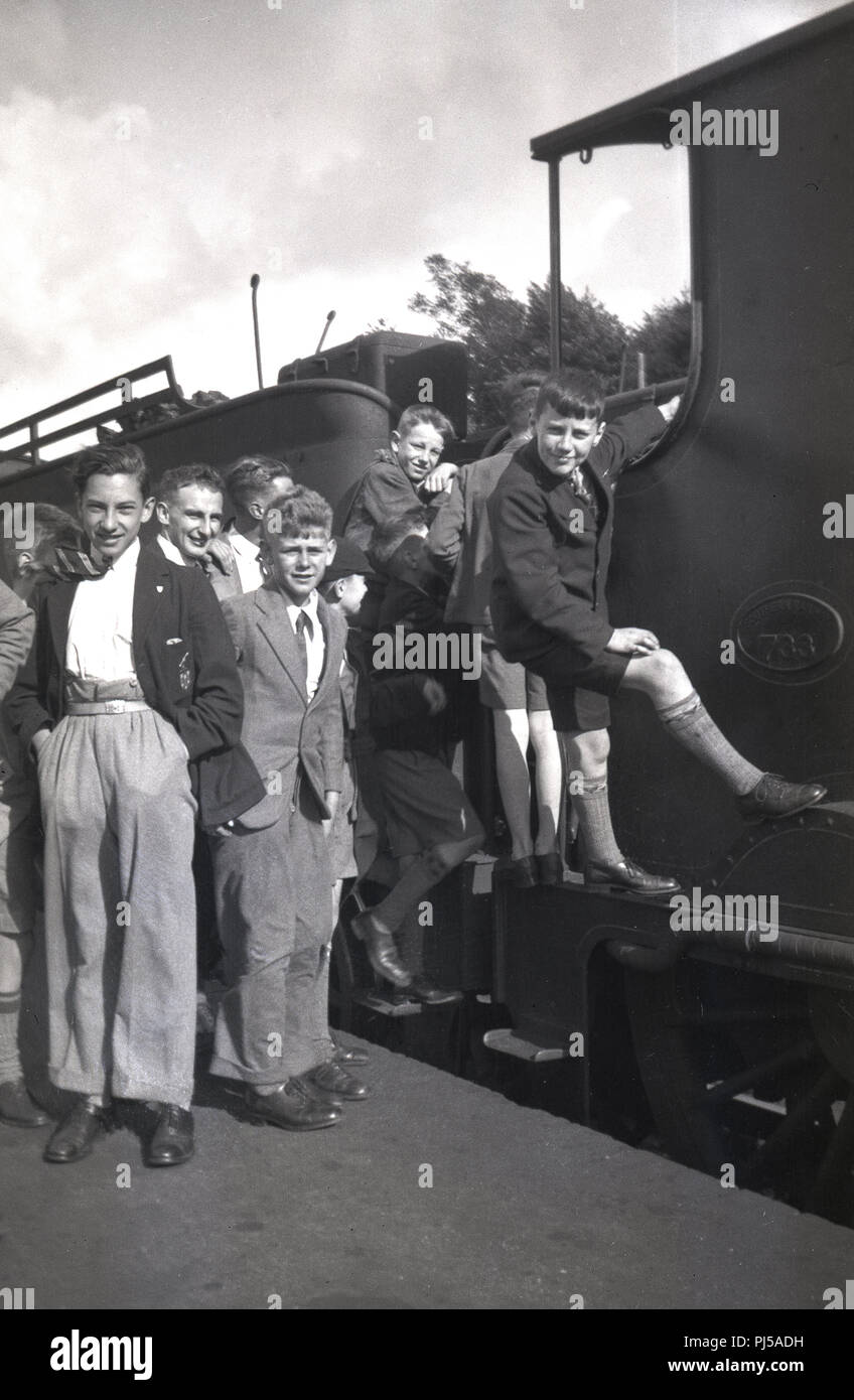 Années 1930, un groupe de collégiens sur un quai de gare à côté, debout sur le côté d'une locomotive à vapeur 733 chemin de fer du Sud, Angleterre, Royaume-Uni. Banque D'Images