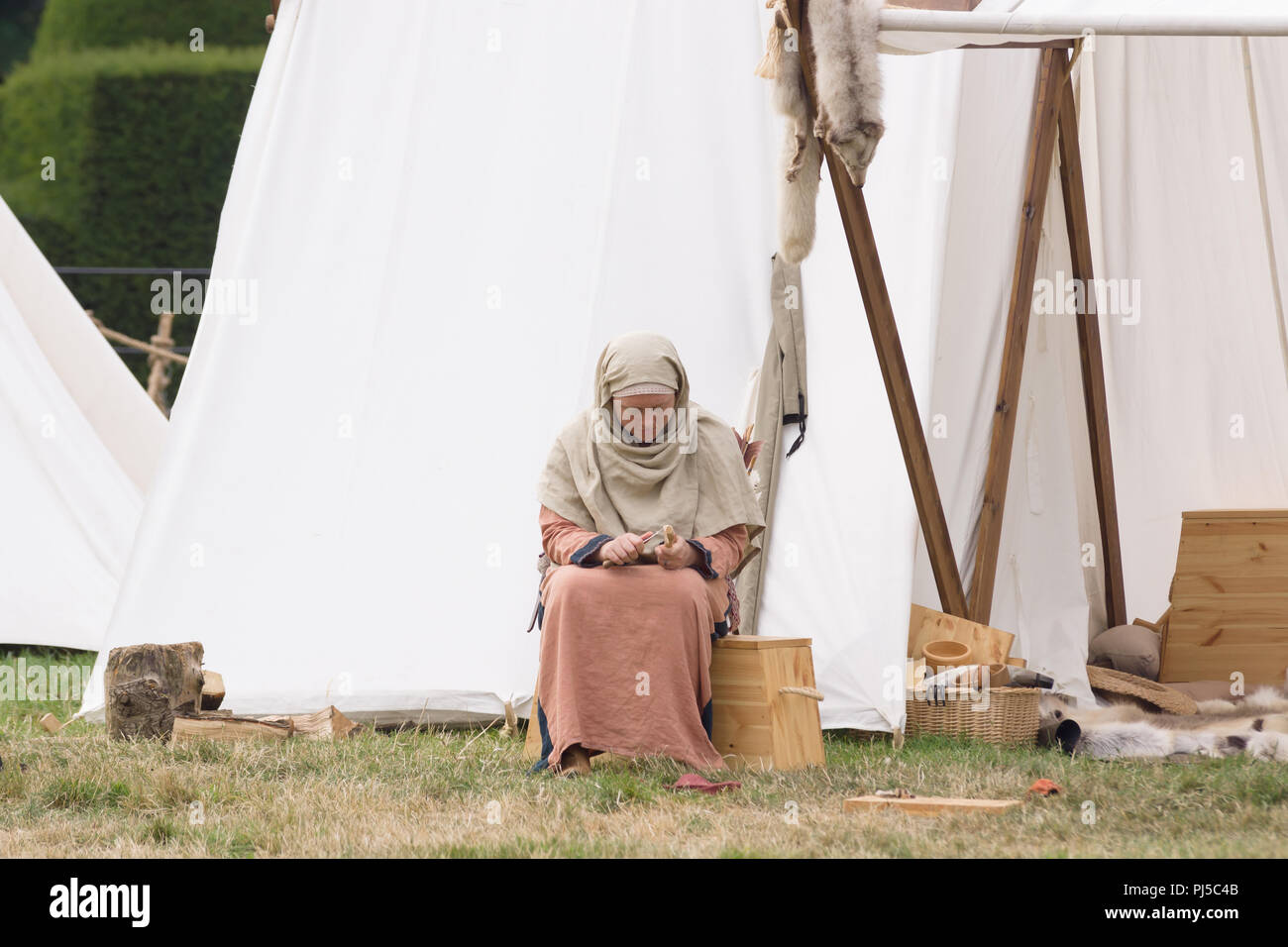 Reconstitution médiévale de la vie dans un camp avec une femme habillée en costume d'époque Banque D'Images