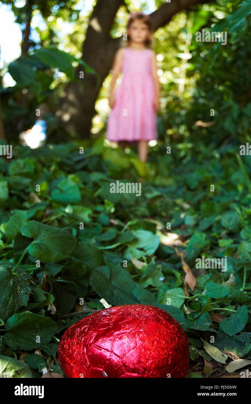 Une petite fille pour la chasse aux oeufs de Pâques en chocolat. Banque D'Images
