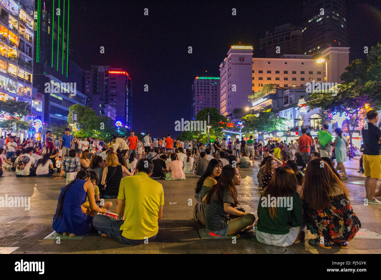 Ho Chi Minh Ville, en Asie - 11 mai 2018 : les jeunes assis dans la foule piéton Nguyen Hue street et de s'amuser Banque D'Images