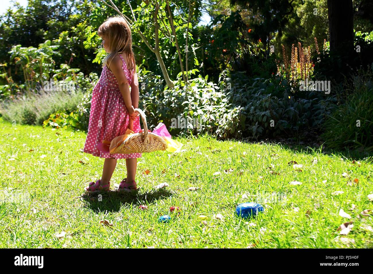 Une petite fille pour la chasse aux oeufs de Pâques en chocolat. Banque D'Images