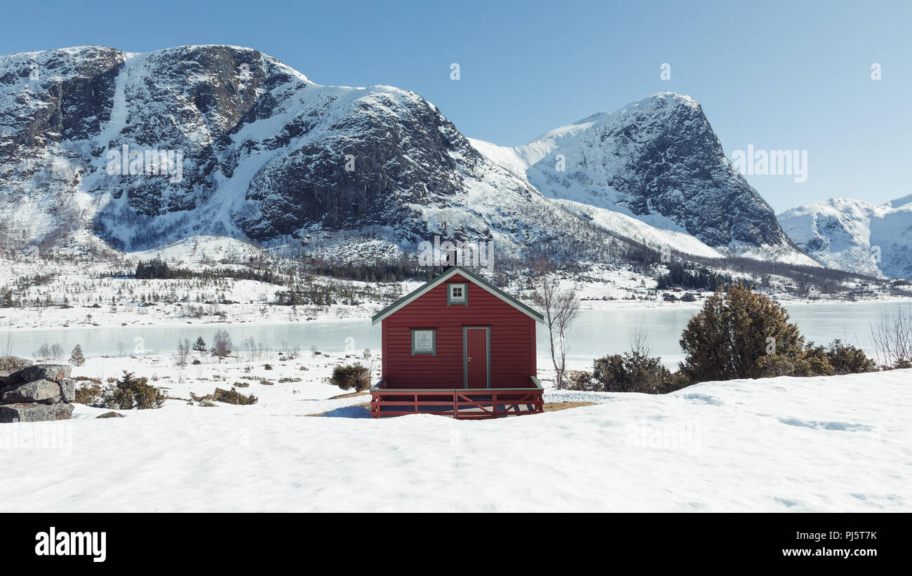 Montagnes couvertes de neige avec cabine au-dessus d'un lac gelé en Norvège Dirdal Banque D'Images