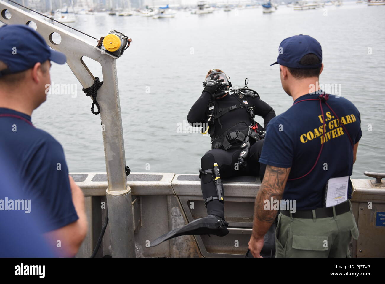 Maître de 2e classe Brian Lehuede, un plongeur de la Garde côtière de plongée régional Ouest casier, Équipe d'intervention de sécurité maritime à l'Ouest, entre dans l'eau dans le cadre de l'opération Clean Sweep le long de 2018 North Harbor Drive, San Diego le 25 août 2018. L'équipe de plongée a été participant à l'opération Clean Sweep 2018, un effort de nettoyage communautaire le long de la baie de San Diego. (U.S. Photo de la Garde côtière du Maître de 2e classe Joel Guzman/libérés) Banque D'Images