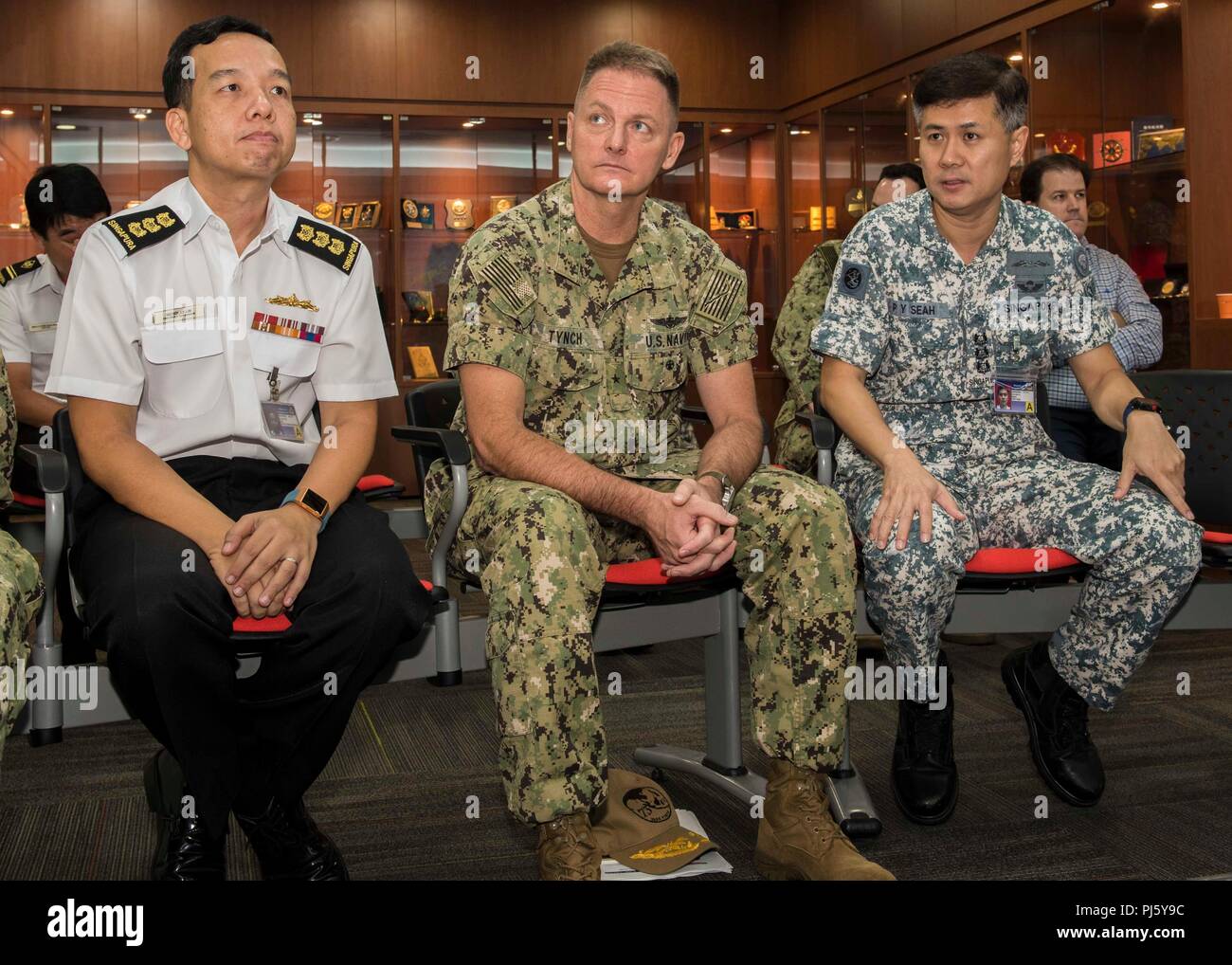 180830-N-FV739-040 BASE NAVALE de Changi, Singapour (30 août 2018) - Arrière Adm. Joey Tynch, commandant de la Task Force 73, est assis avec le colonel de la Marine de la République de Singapour Seah Poh Yeen, commandant, Maritime Security Task Force, et le colonel Nicolas Lim, commandant du groupe Sensibilisation maritime globale, au cours d'une visite de Singapour au centre de fusion de l'information à l'appui de l'Asie du sud-est de la coopération et de la formation (SEACAT). C'est le 17e congrès annuel de l'exercice et le Seacat comprend les participants en provenance des États-Unis, le Brunei, le Bangladesh, la Thaïlande, les Philippines, Singapour, Vietnam, Malaisie et Indonésie. (U.S. Photo de la marine en masse Banque D'Images