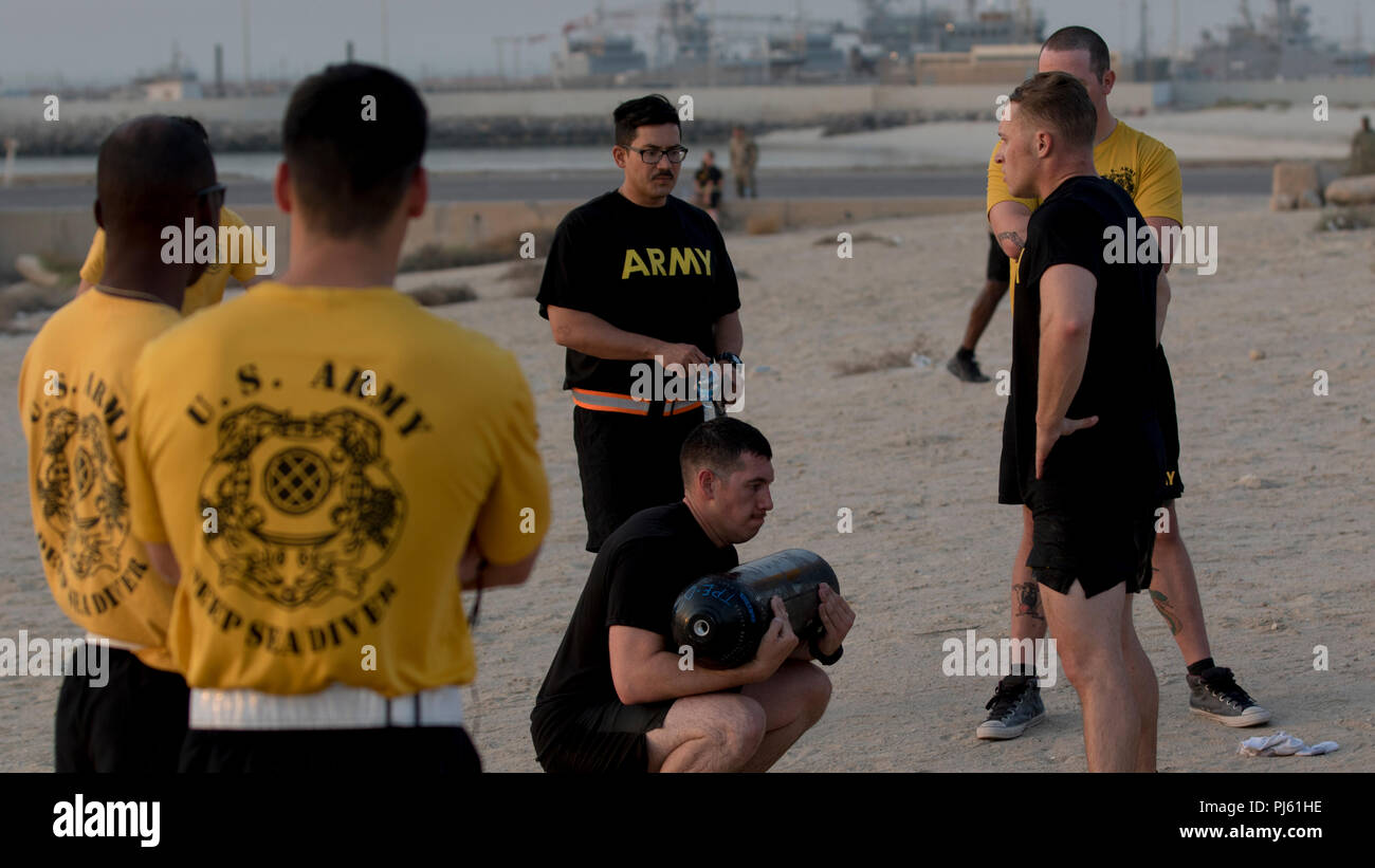 Un soldat de l'armée américaine s'accroupit avec un réservoir d'air avant de le remettre à son coéquipier à la 74e Détachement de plongée plongeur Ingénieur du Fitness Challenge à Koweït Le Koweït, la base navale, le 31 août 2018. Les soldats qui ont participé au Défi illustré de remise en forme plongée l'armée américaine accorde à l'excellence. (U.S. Photo de l'armée par la CPS. Adam Parent) Banque D'Images