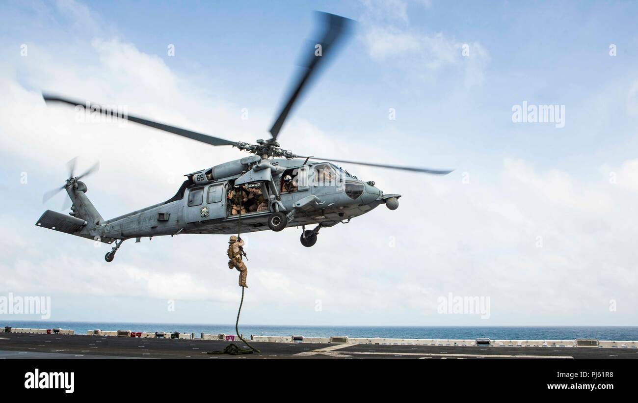 Océan Indien - U.S. Marine Lance Cpl. Alexandre Huynh, un carabinier avec Lima Company, bataillon de l'équipe d'atterrissage (BLT) 3/1, 13e Marine Expeditionary Unit (MEU), fast-cordes d'un hélicoptère MH-60 à bord de la classe Wasp-navire d'assaut amphibie USS Essex (DG 2), le 2 septembre 2018. Essex est le navire amiral de la Essex ARG et, avec l'entrepris 13e MEU, est déployé sur le 5e flotte américaine zone d'opérations à l'appui des opérations navales pour assurer la stabilité et la sécurité maritime dans la région Centrale, reliant la Méditerranée et le Pacifique à travers l'ouest de l'Océan indien et trois axes stratégiques Banque D'Images