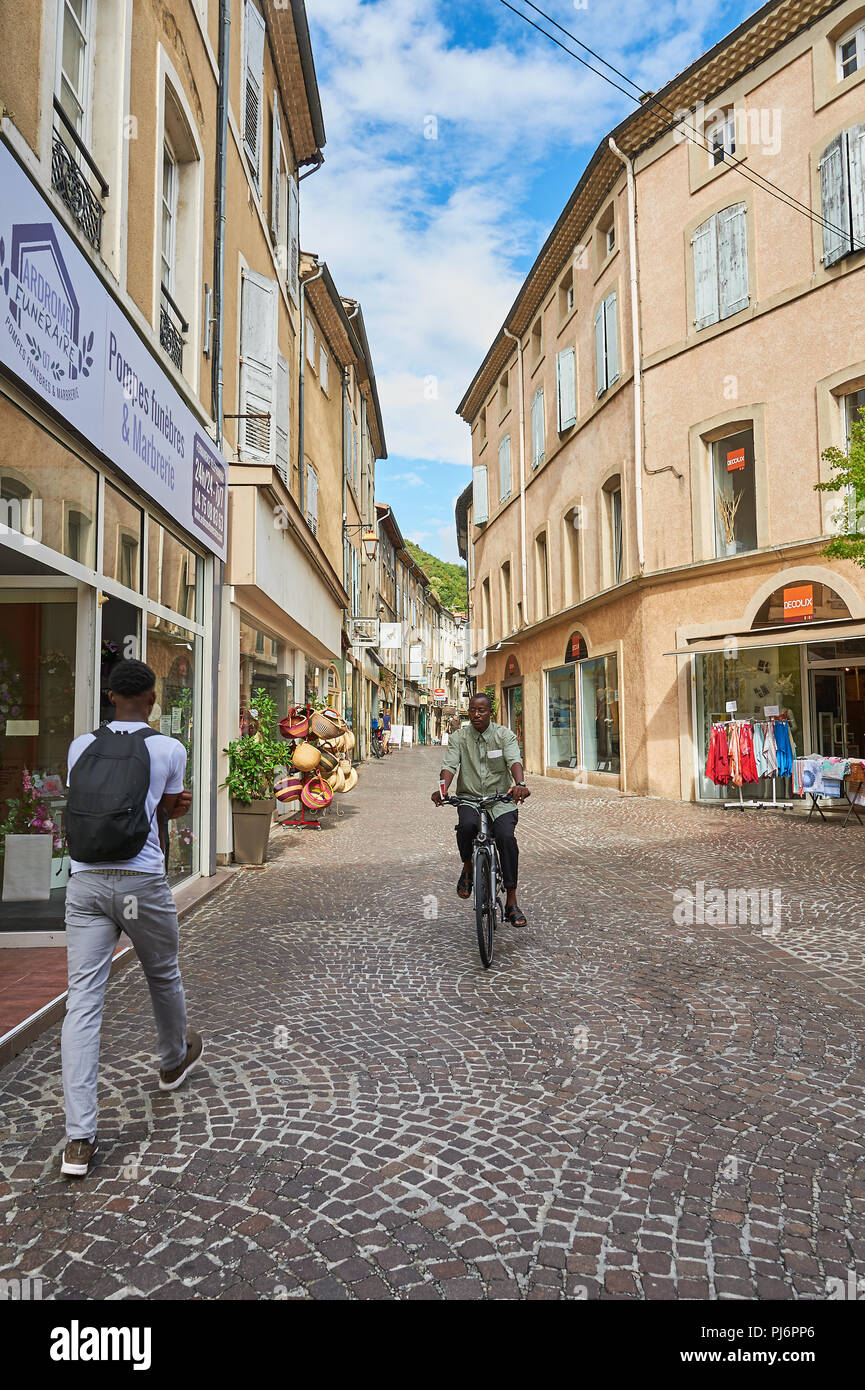 Tournon sur Rhone, Ardèche, Rhône-Alpes, France un homme monté sur un vélo et un homme marche à travers le centre-ville Banque D'Images