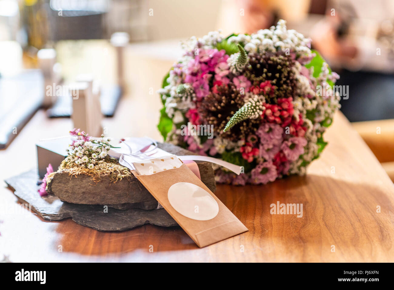 Beau mariage fleurs et tissus cri se situent sur la surface en bois contre l'arrière-plan d'un bouquet de fleurs et couple de mariage Banque D'Images