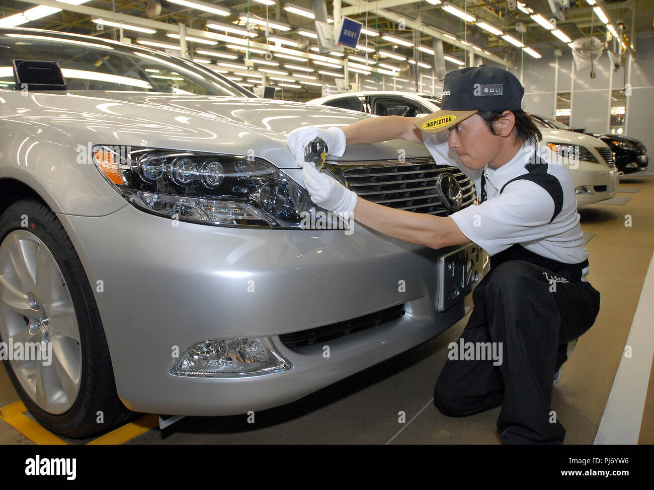 Un travailleur inspecte le corps d'un véhicule Lexus Toyota Motor Corp. pour irrégularités à bord au niveau de l'usine de la compagnie à Toyohashi City, Japon o Banque D'Images