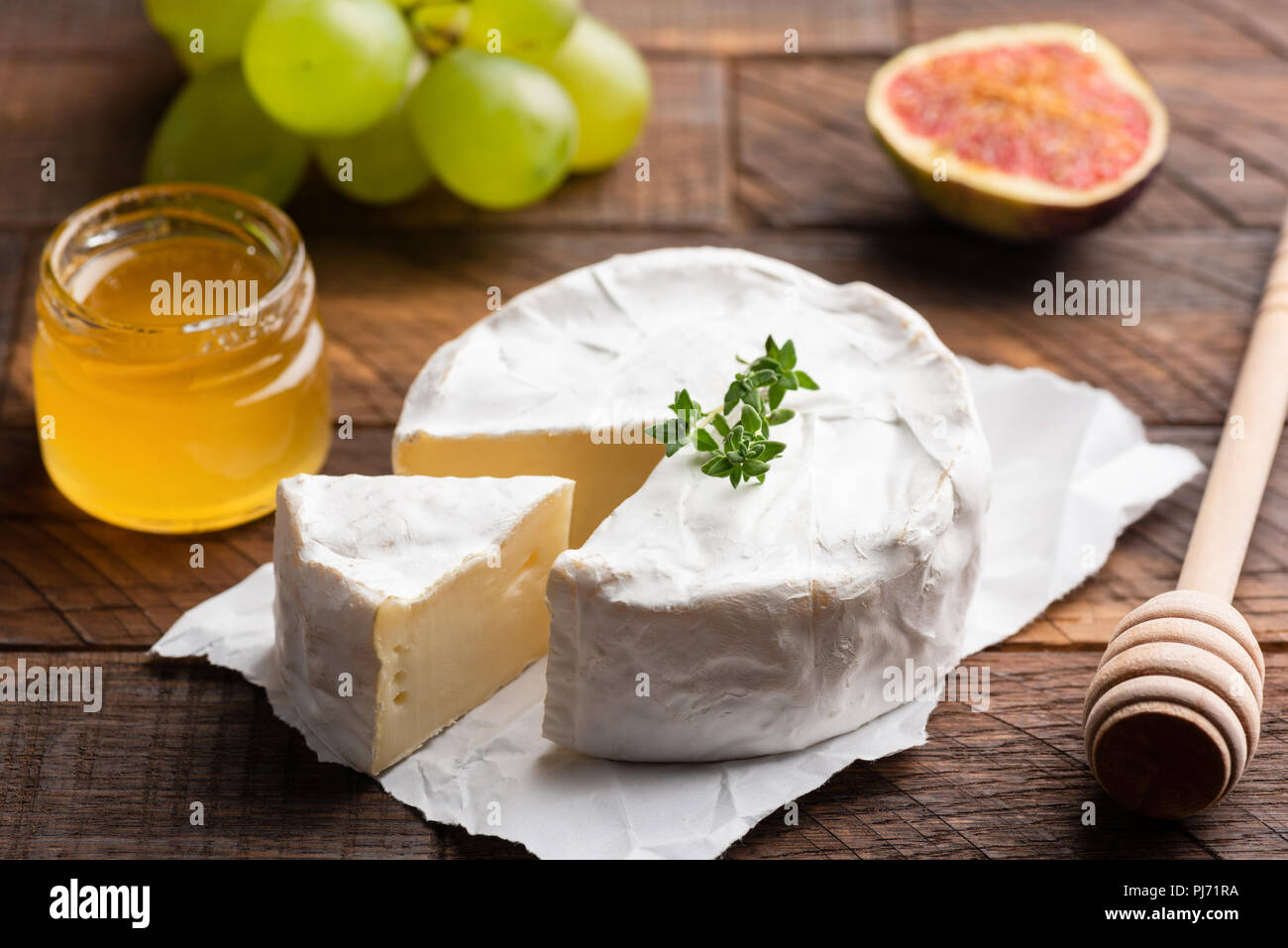 Brie ou camembert aux figues, raisins et miel sur bois Banque D'Images