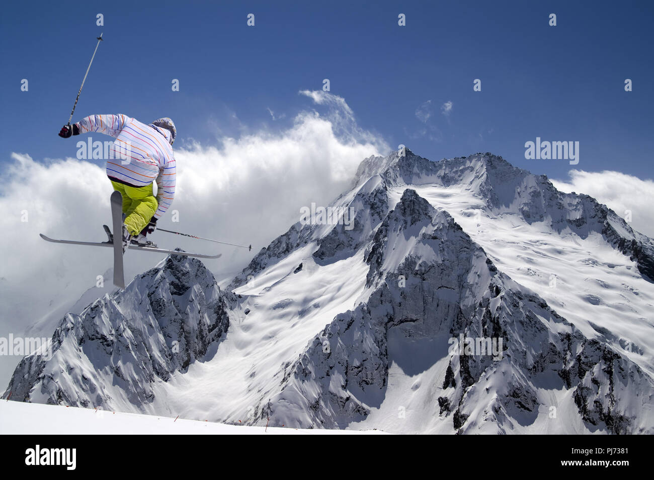 Ski freestyle avec skis croisés dans les hautes montagnes enneigées en hiver jour soleil Banque D'Images