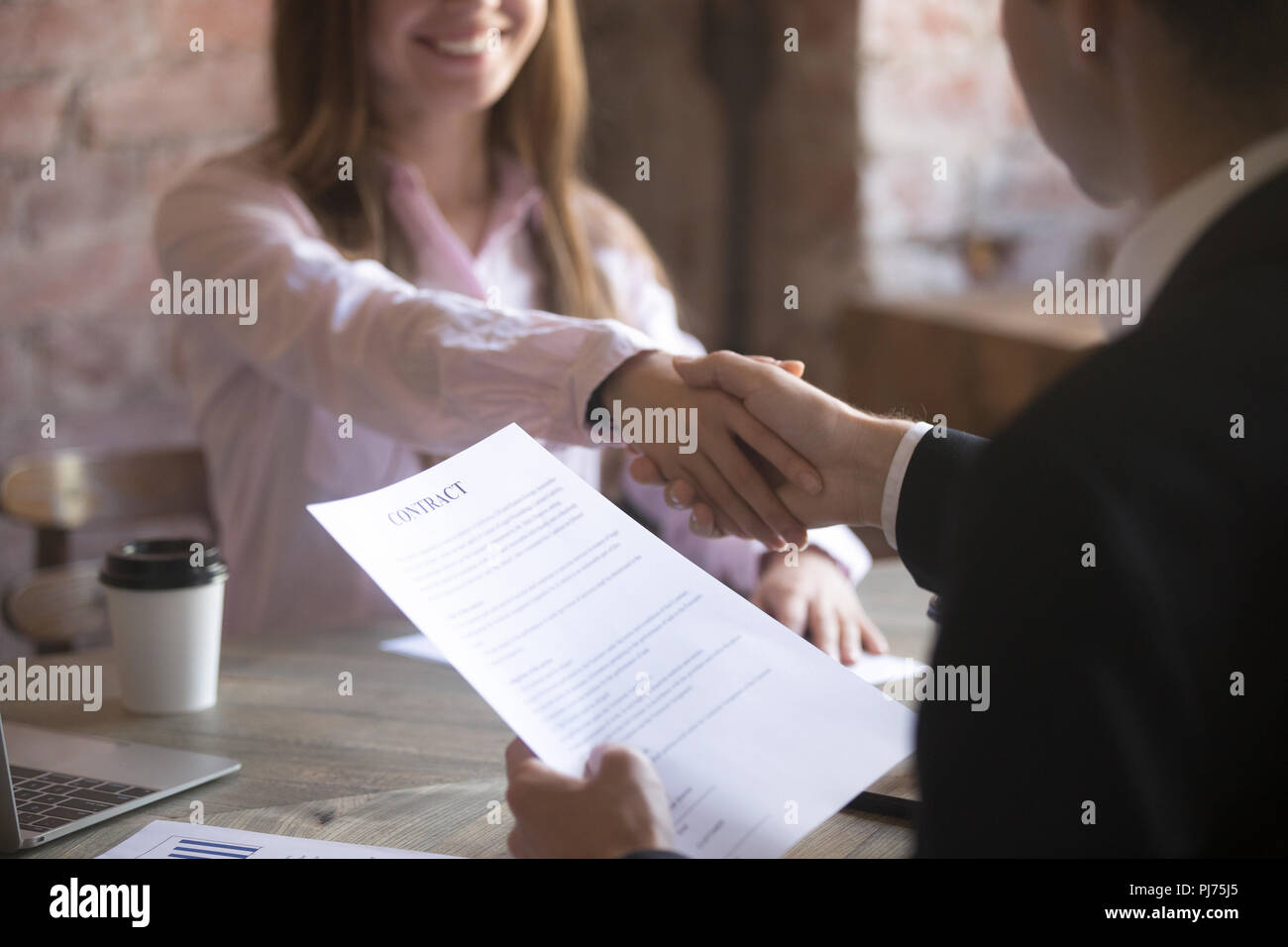 Souriante jeune femme et l'homme poignée de main. Accord Banque D'Images