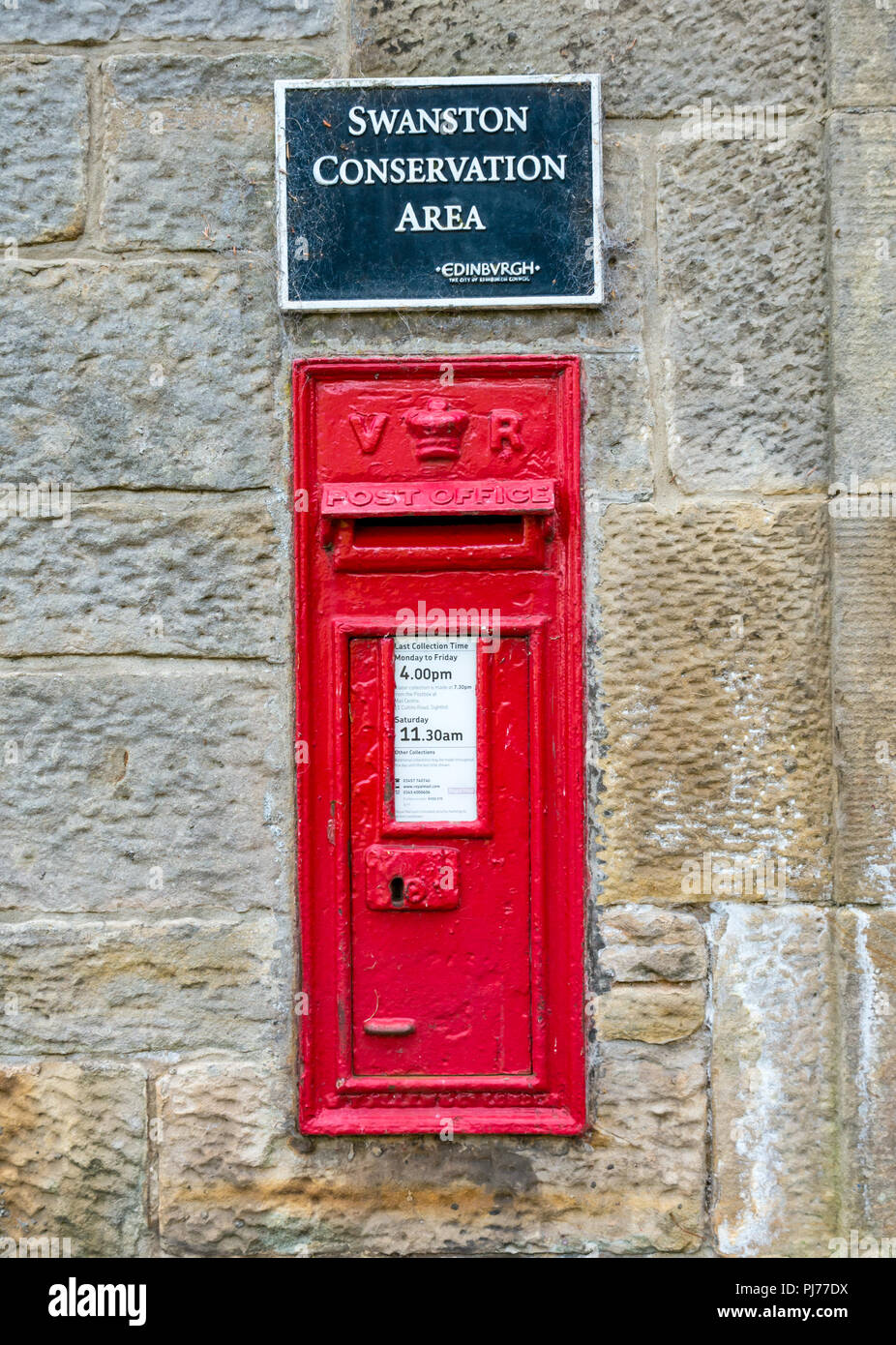 Old fashioned red iconique postbox dans mur de pierre, avec Swanston Conservation Area sign, Édimbourg, Écosse, Royaume-Uni Banque D'Images