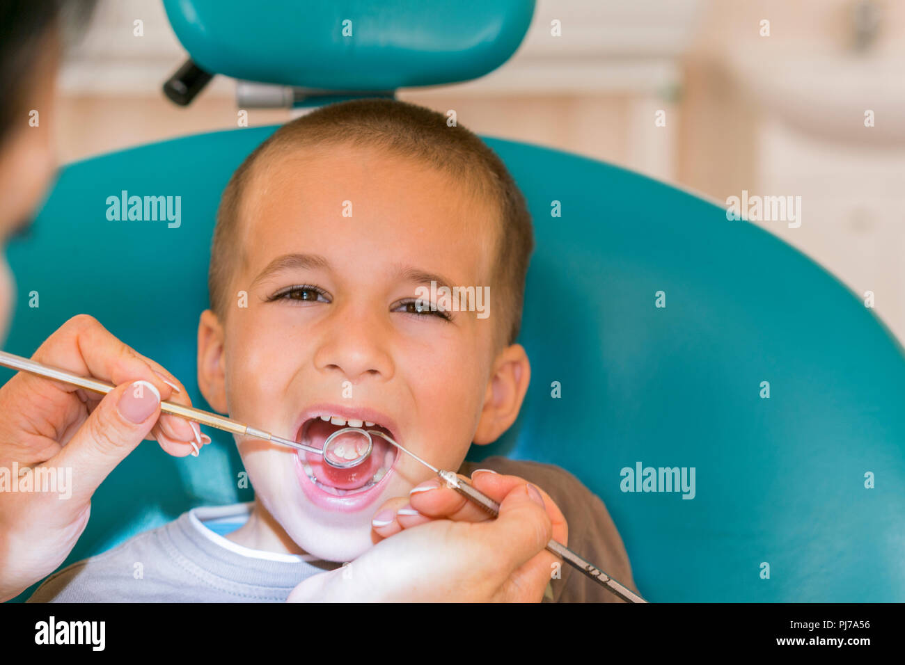 Pédodontiste examinant un peu de garçons dans les dents dentistes président  à la clinique dentaire. L'examen de dentiste dents du petit garçon dans une  clinique Photo Stock - Alamy