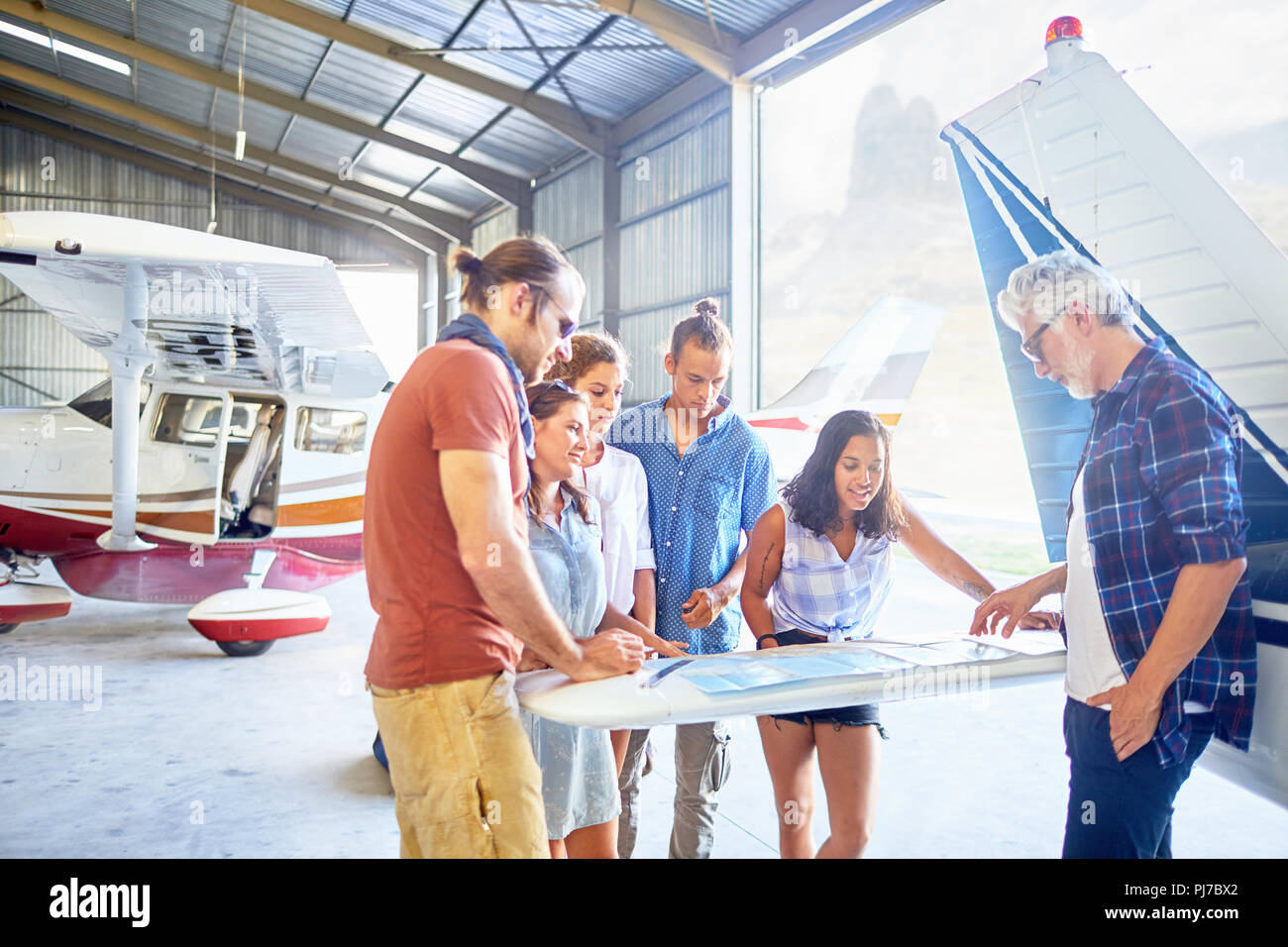 La planification d'amis voyage à la carte au hangar avion Banque D'Images