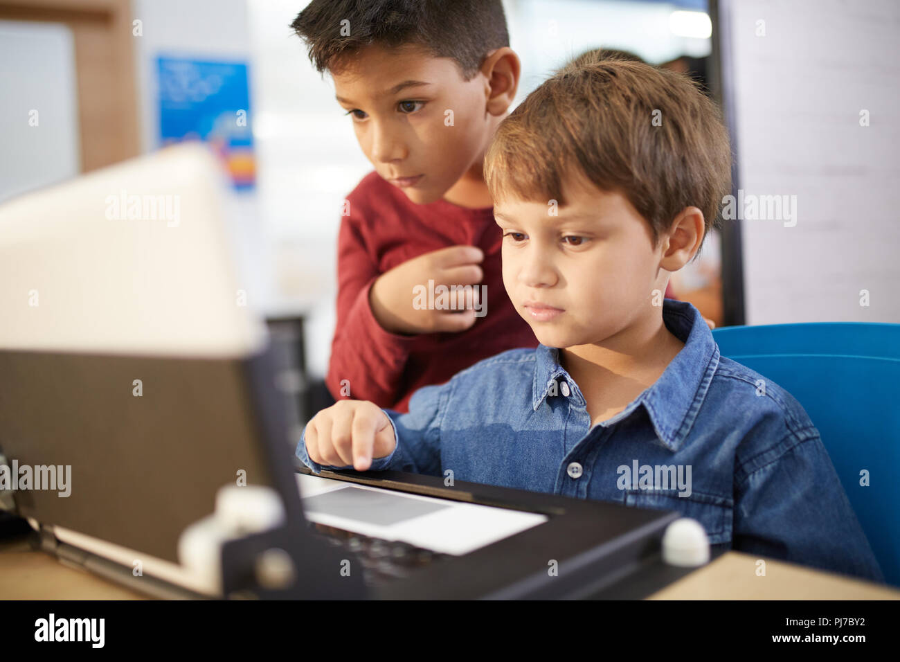Les garçons à l'aide d'ordinateur portable porté Banque D'Images