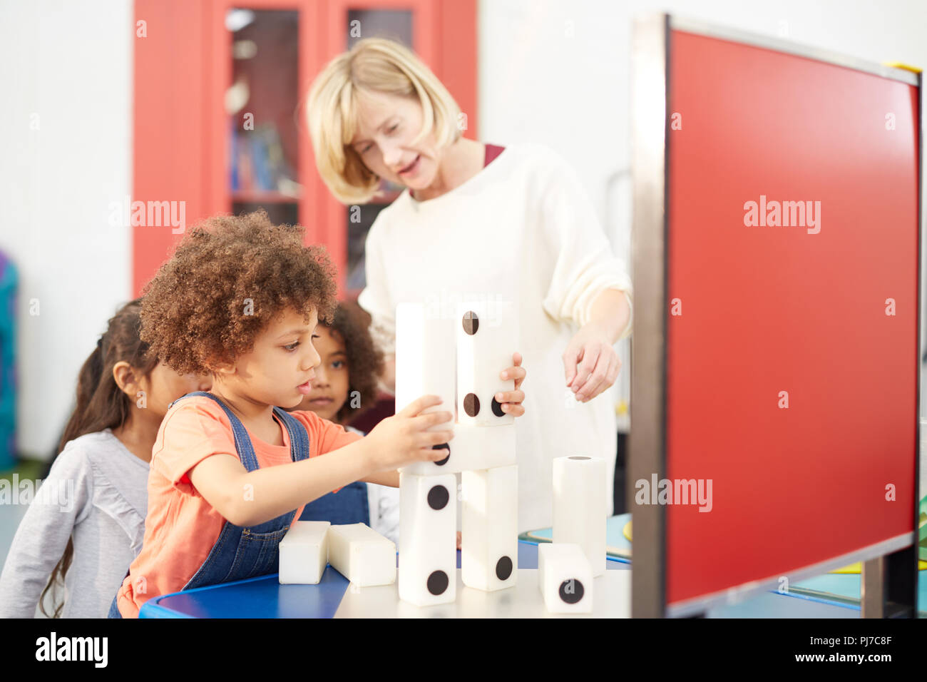 Professeur et étudiants curieux grand empilage dominos dans science center Banque D'Images